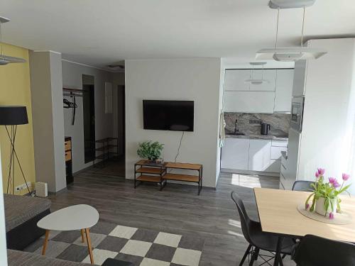 a living room with a table and chairs and a tv at Pärnu südalinna majutus in Pärnu