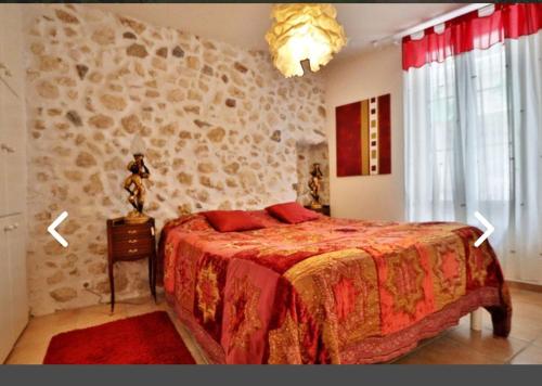 une chambre avec un lit et un mur en pierre dans l'établissement Gîte des Vignerons, à Salles-d'Aude