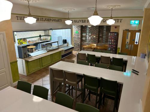 a restaurant with white tables and green chairs at Gogartys Temple Bar Hostel in Dublin