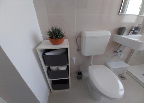 a small bathroom with a toilet and a sink at Studio M in Pula