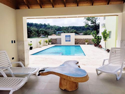 a pool with a table and chairs next to a swimming pool at Confortable Apartamento con Piscina en Cabrera in Cabrera
