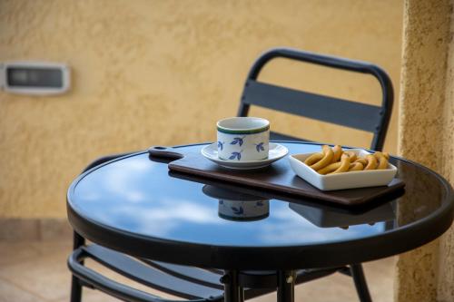 a table with a coffee cup and french fries on it at The Garden House in Aegina Town