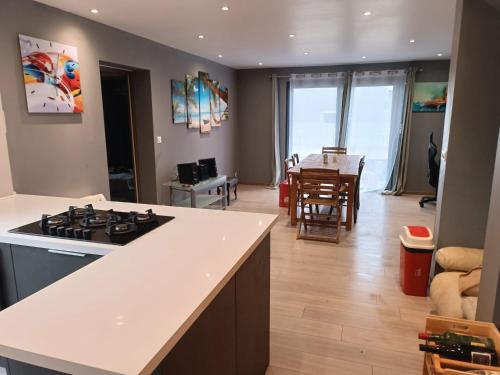 Il comprend une cuisine et un salon avec une cuisinière et une table. dans l'établissement Chambres à Vacquières, à Vacquières