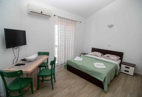 Schlafzimmer mit einem Bett, einem Tisch und einem TV in der Unterkunft Cape Kamenjak Apartments in Premantura in Premantura