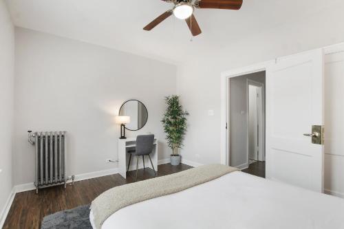 - une chambre avec un lit blanc et un ventilateur de plafond dans l'établissement Well-Equipped 1BR Apt in Hyde Park - Harper 404, à Chicago