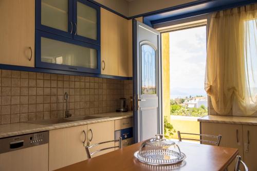 a kitchen with a table and a large window at The Garden House in Aegina Town