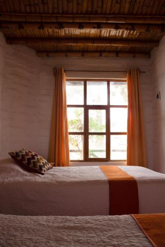 a bedroom with two beds and a window at La Estancia Chincha Hotel in Chincha Alta