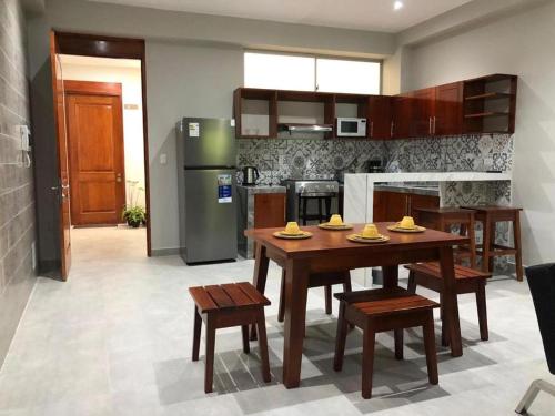 a kitchen with a table and chairs and a refrigerator at Bellazio Aparthotel in Iquitos
