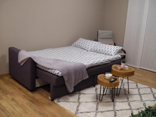 - un lit dans une chambre avec 2 tables dans l'établissement Appartamento ARCOBALENO, à Tirano