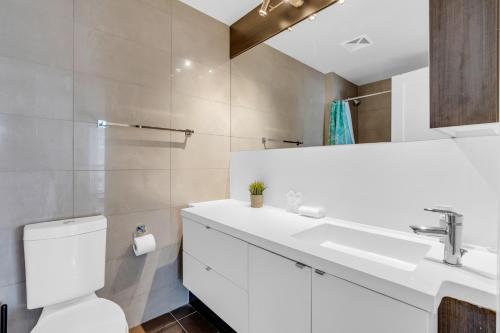 a bathroom with a white sink and a toilet at Modern Downtown Suites in Toronto