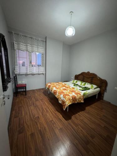 um quarto com uma cama e uma cadeira em SN Apartment city center em Shkodër