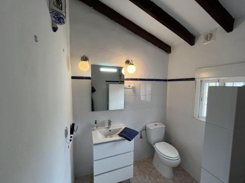 een witte badkamer met een toilet en een wastafel bij Cortijo Pura Vida in Cómpeta