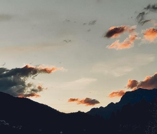 a sunset over the mountains with clouds in the sky at La Bohemia de Potes in Potes