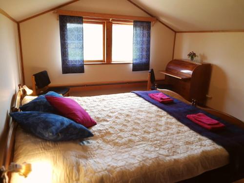 um quarto com uma cama com almofadas e um piano em Vackert och fridfullt i jordhus, 90 kvm em Nyköping