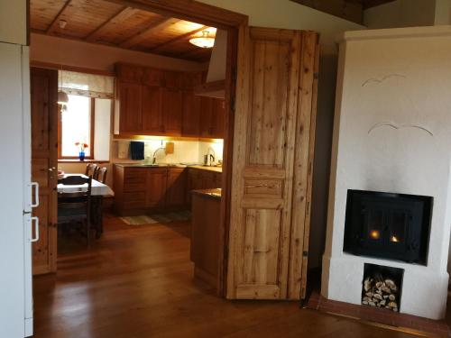 een woonkamer met een open haard en een keuken bij Vackert och fridfullt i jordhus, 90 kvm in Nyköping