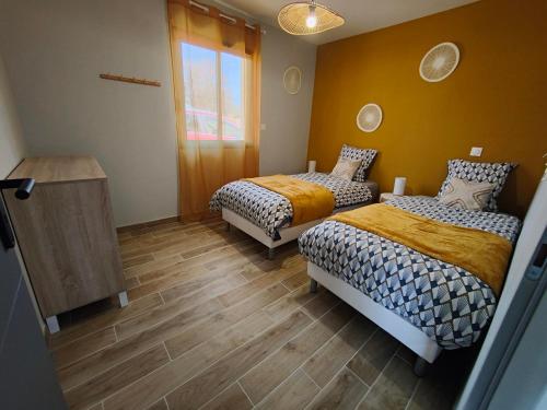 a bedroom with two beds and a window at Les bambous - 2 logements 10min du zoo neuf-confort-famille-jeux pour enfants in Saint-Romain-sur-Cher