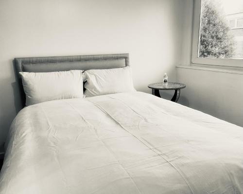 białe łóżko w sypialni z oknem w obiekcie Newly Renovated 2BR Apartment in the heart of London w Londynie