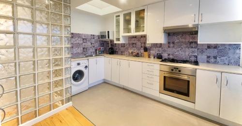 kuchnia z białymi szafkami, pralką i suszarką w obiekcie Newly Renovated 2BR Apartment in the heart of London w Londynie