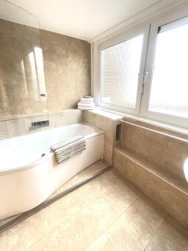 W łazience znajduje się wanna, prysznic i umywalka. w obiekcie Newly Renovated 2BR Apartment in the heart of London w Londynie