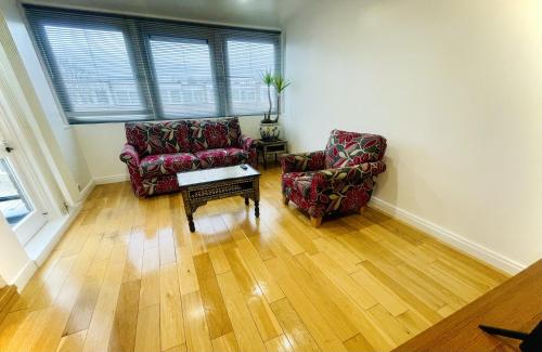 salon z 2 krzesłami i stolikiem kawowym w obiekcie Newly Renovated 2BR Apartment in the heart of London w Londynie
