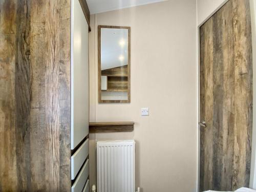a hallway with a mirror and a wooden door at Brookwood in Weston-super-Mare