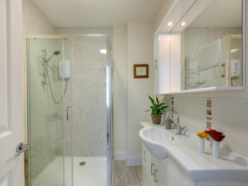 a bathroom with two sinks and a glass shower at Poppin-uk47165 in Brixham