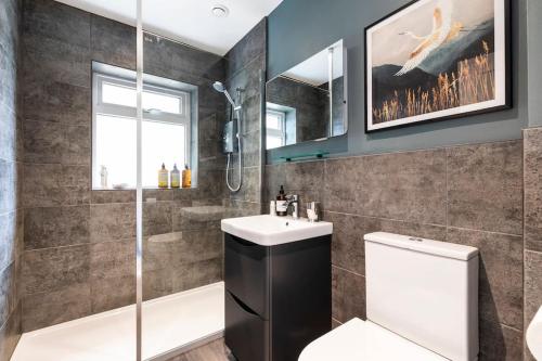a bathroom with a shower and a toilet and a sink at 'The Cobbles' - central, stylish, garden, views in Skipton