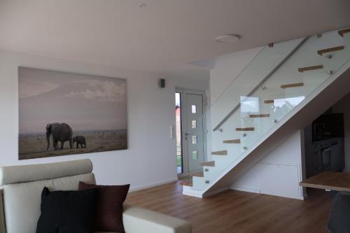 a living room with a staircase with a picture of a elephant at Modernes Privathaus am See mit Highspeed-Internet in Sassenburg