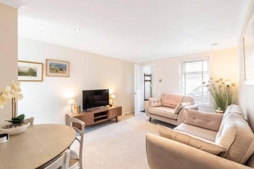 a living room with a couch and a tv at 'The Cobbles' - central, stylish, garden, views in Skipton