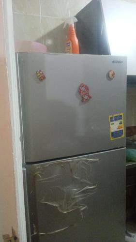 una nevera con imanes en la cocina en New-Fayoum Apartment, en Minshāt Kamāl