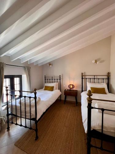 2 camas en una habitación con techo blanco en Renovated cinema town house in Comares, en Málaga