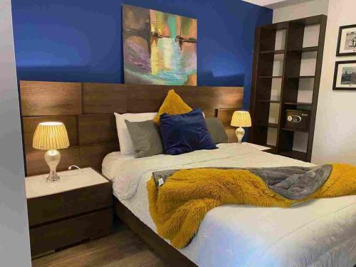 a bedroom with a bed with a yellow blanket at Apartamento cerca a Embajada EEUU - Cayala Zona 16 