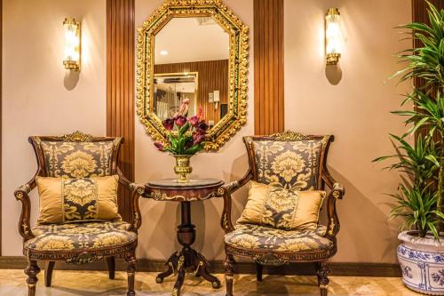 two chairs and a table with a mirror at Odst Jeddah in Jeddah