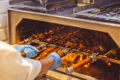 a person is putting food into an oven at Crowne Plaza Zhengzhou High Tech Zone by IHG in Zhengzhou