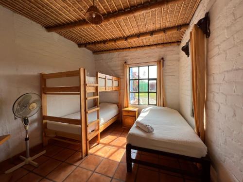 a bedroom with two bunk beds and a window at La Estancia Chincha Hotel in Chincha Alta