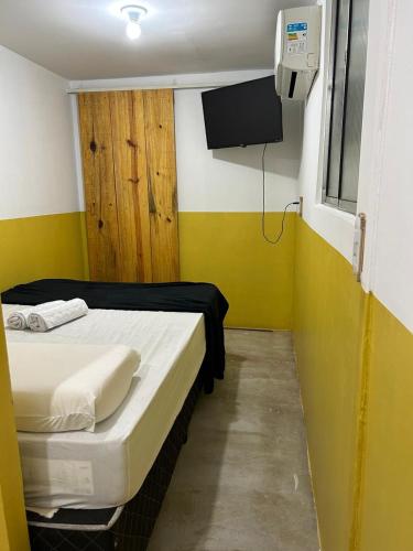 a small room with a bed and a tv at Tiny Lagoa in Jijoca de Jericoacoara