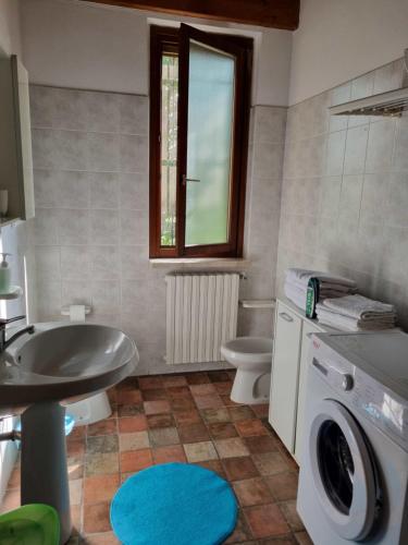 a bathroom with a sink and a washing machine at Agriturismo Case in Collina in Volta Mantovana