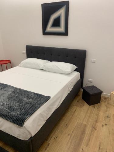 a bed with a black headboard in a bedroom at Casa Vacanze Ibiscus in Portovenere