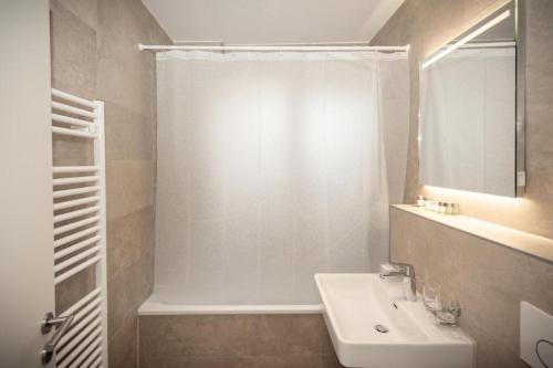 a white bathroom with a sink and a shower at FBC Room Business in Rødby