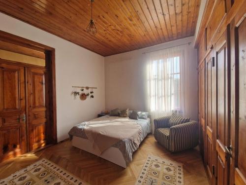 een slaapkamer met een bed, een raam en een stoel bij Villa Natanebi 