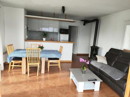 un salon avec un canapé et une table dans l'établissement Rez de jardin, vue panoramique, plein Sud, à Puy-Sanières