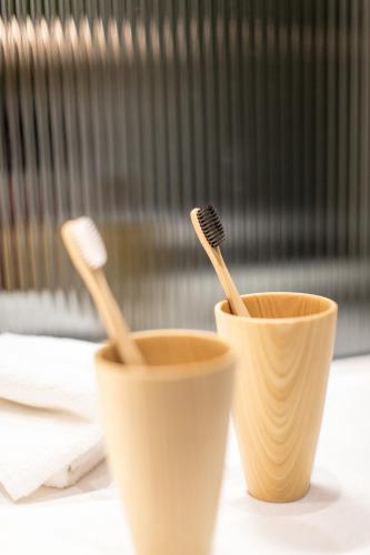 two cups with toothbrushes sitting on a table at Stanford Hillview Hotel Hong Kong in Hong Kong