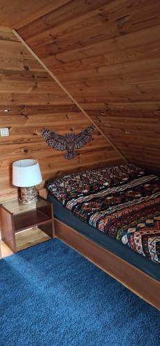 a bedroom with a bed with a butterfly on the wall at Dream Forest Cabin in Warsaw