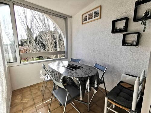 une salle à manger avec une table et des chaises et une fenêtre dans l'établissement Résidence Cote D'oc - Appartement deux pièces mezzanine - 4 couchages PORT LEUCATE. 2CO_35B MAE-7041, à Leucate