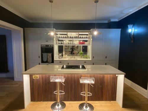 a kitchen with a sink and a counter with stools at Beach House in Swanage