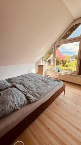 a bedroom with a bed and a large window at Ferienhaus mit Seeblick in Templin