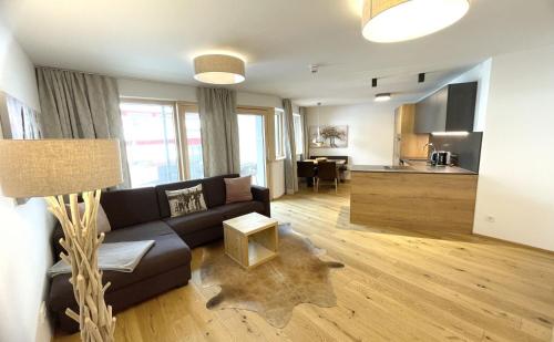 a living room with a couch and a kitchen at Spa Apartments - Zell am See in Zell am See