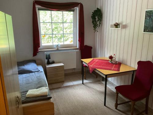a room with a table and a bed and a window at Gasthaus Kienbaum in Kienbaum