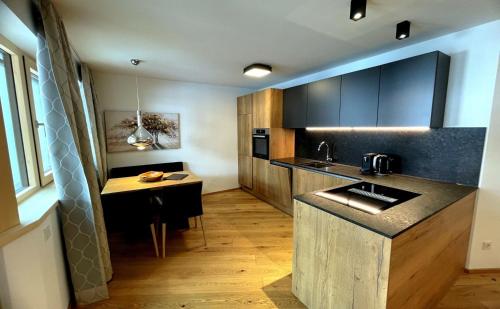 a kitchen with a counter and a table in it at Spa Apartments - Zell am See in Zell am See