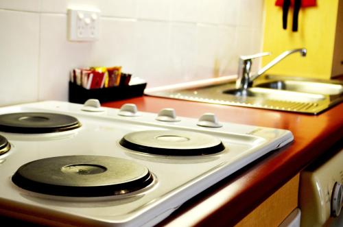 a white stove top with a sink in a kitchen at Spring Hill Mews Apartments in Brisbane